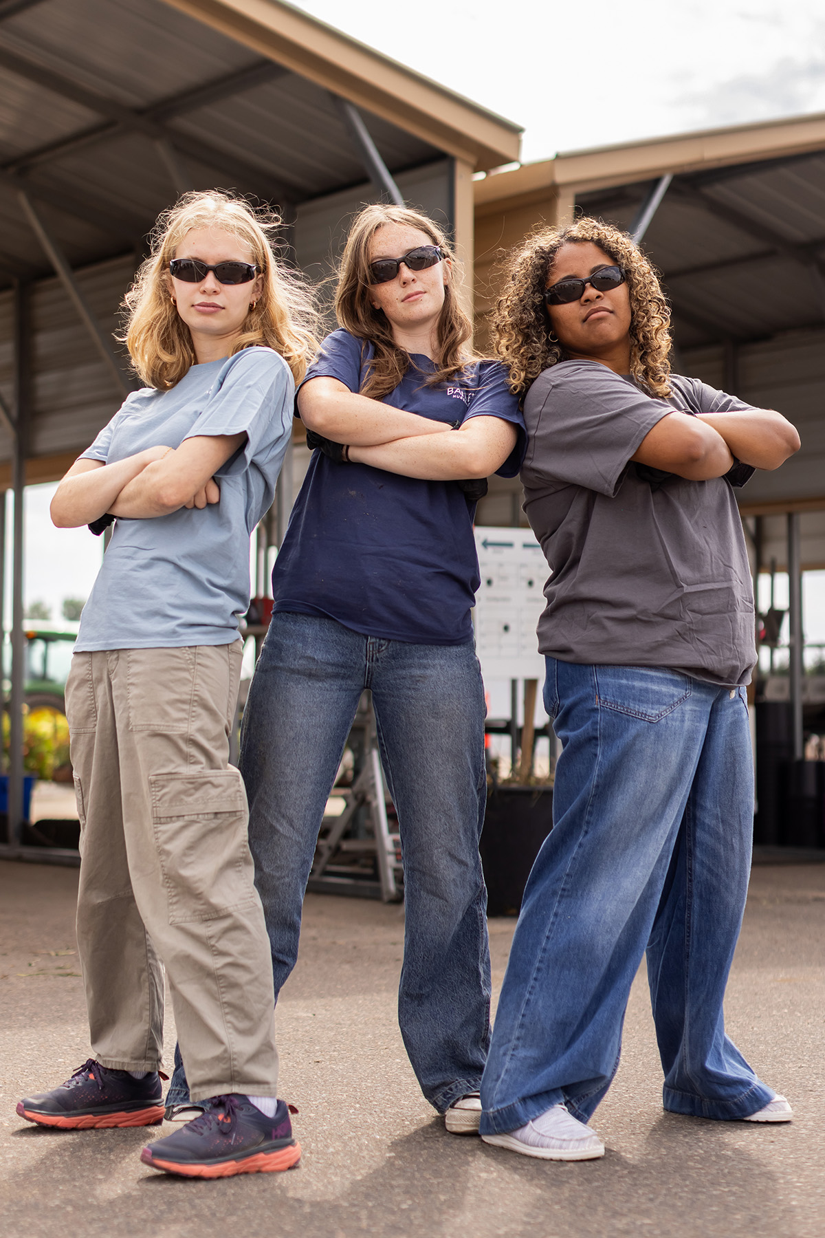 Three interns strike a playful B-boy stance outside the Container East loading area.