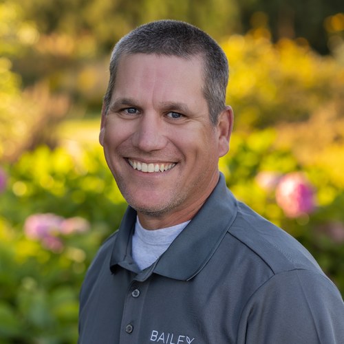 Ross Dumdi smiling outdoors in a Bailey Nurseries shirt.